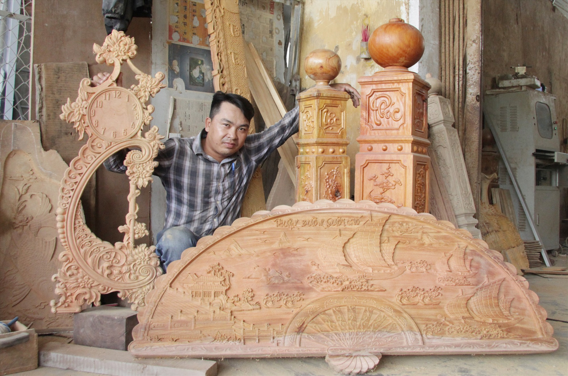 Anh Hồ Văn Công bên những sản phẩm gia công gỗ mỹ nghệ của mình chế tác. Ảnh: H.Q