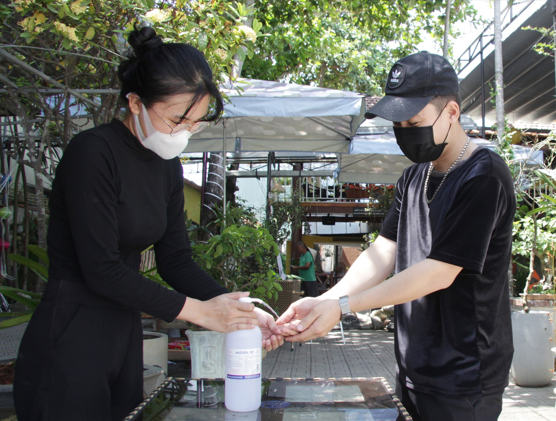 Khách hàng được yêu cầu sát khuẩn trước khi vào một quán cafe trên đường Nguyễn Du. Ảnh: Q.H