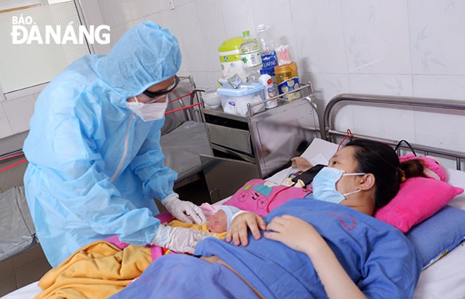 Bác sĩ Võ Thị Nhung thăm khám, dặn dò mẹ con sản phụ Đặng Ngọc Thảo Ly. Ảnh: PHAN CHUNG