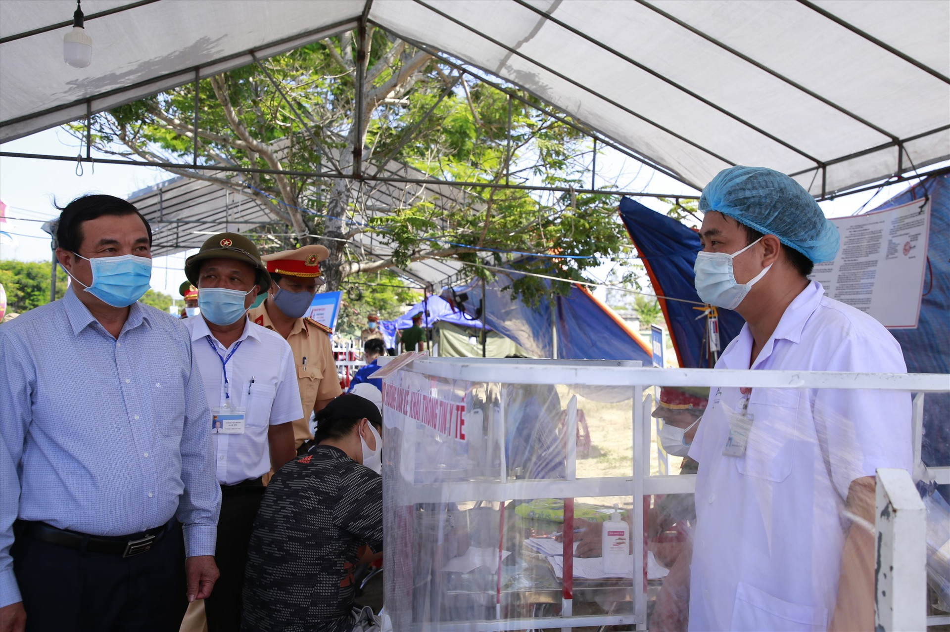 Bí thư Tỉnh ủy Phan Việt Cường thăm hỏi một cán bộ y tế làm nhiệm vụ tại chốt kiểm soát trên tuyến ĐT 603 thuộc thị xã Điện Bàn. Ảnh: T.C