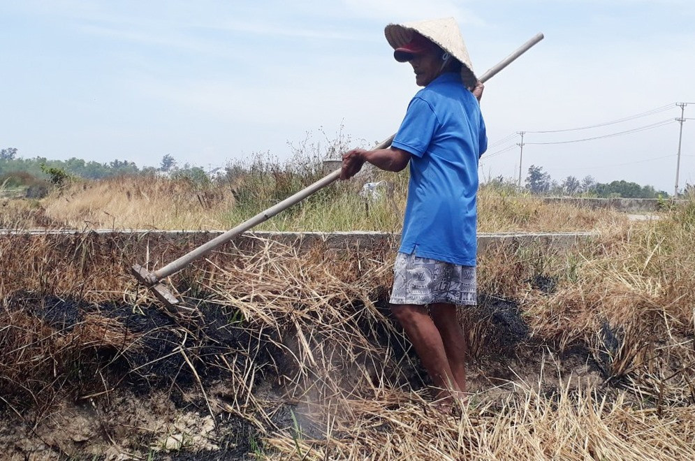 Một người dân đang tranh thủ đốt rạ, vệ sinh đồng ruộng đợi nước về mới tiến hành gieo sạ. Ảnh: Q.H