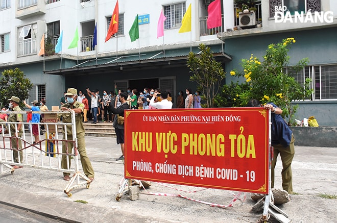 Lực lượng chức năng tiến hành gỡ thiết lập vùng cách ly y tế đối với chung cư 12T3 (quận Sơn Trà) sáng 27-5. Ảnh: XUÂN DŨNG