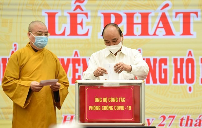 Chủ tịch nước Nguyễn Xuân Phúc và Chủ tịch UBTƯ MTTQ Việt Nam Đỗ Văn Chiến cùng các đại biểu chung tay ủng hộ công tác phòng, chống dịch