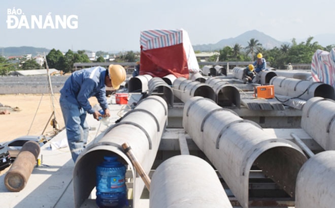 Công nhân tập trung thi công nhà máy xử lý nước thuộc dự án Nhà máy nước Hòa Liên để hoàn thành vào ngày 30-6-2021.    Ảnh: HOÀNG HIỆP