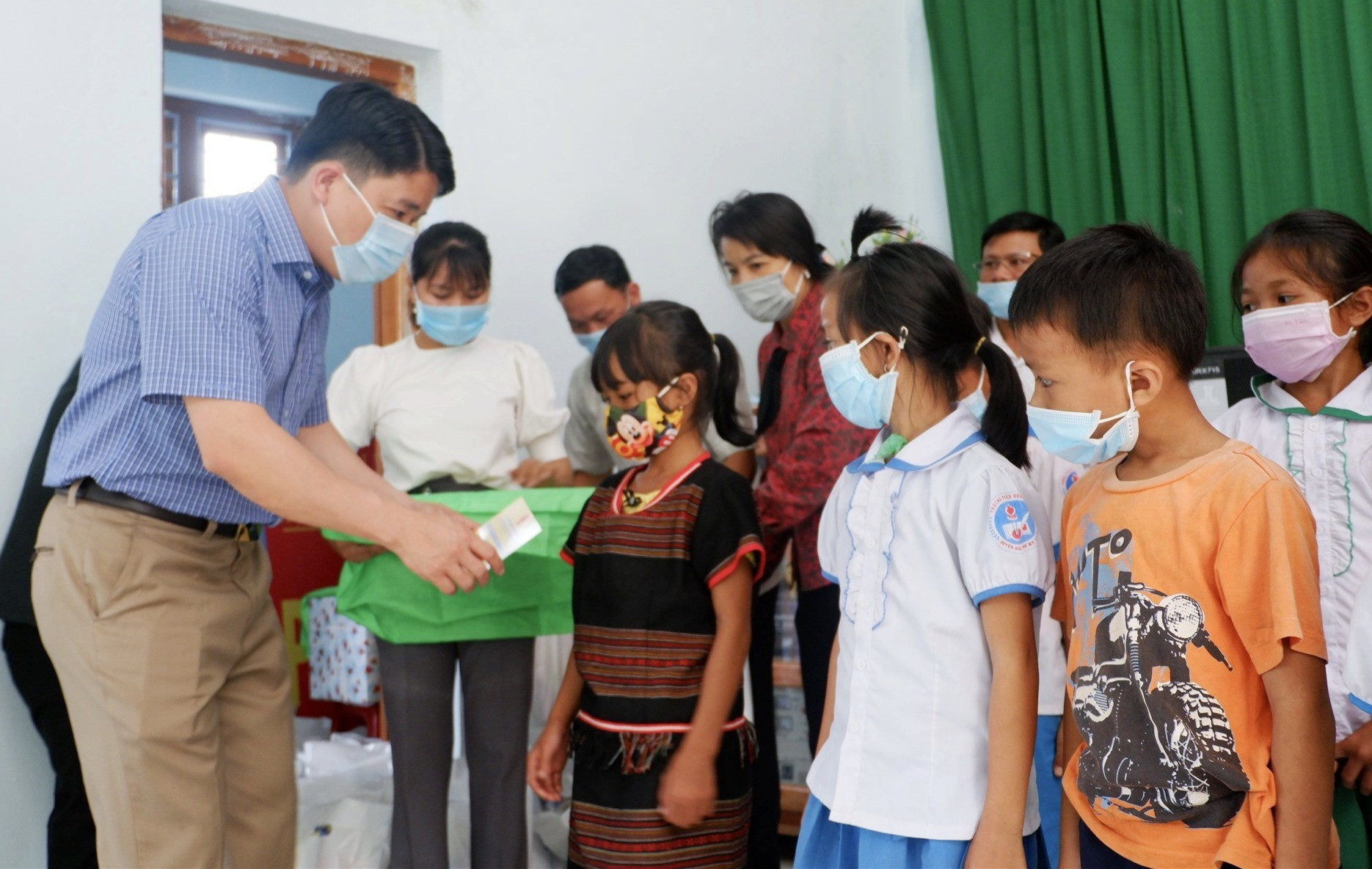 Phó Chủ tịch UBND tỉnh Trần Văn Tân tặng quà cho các em xã Trà Bui. Ảnh: X.H