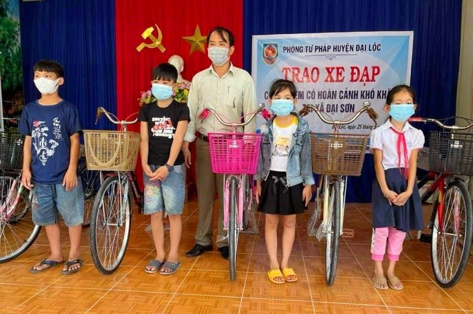 Ông Võ Ngọc Tốt - Trưởng phòng Tư pháp huyện Đại Lộc trao xe đạp “Tiếp sức đến trường” cho trẻ em Đại Sơn. Ảnh: T.N