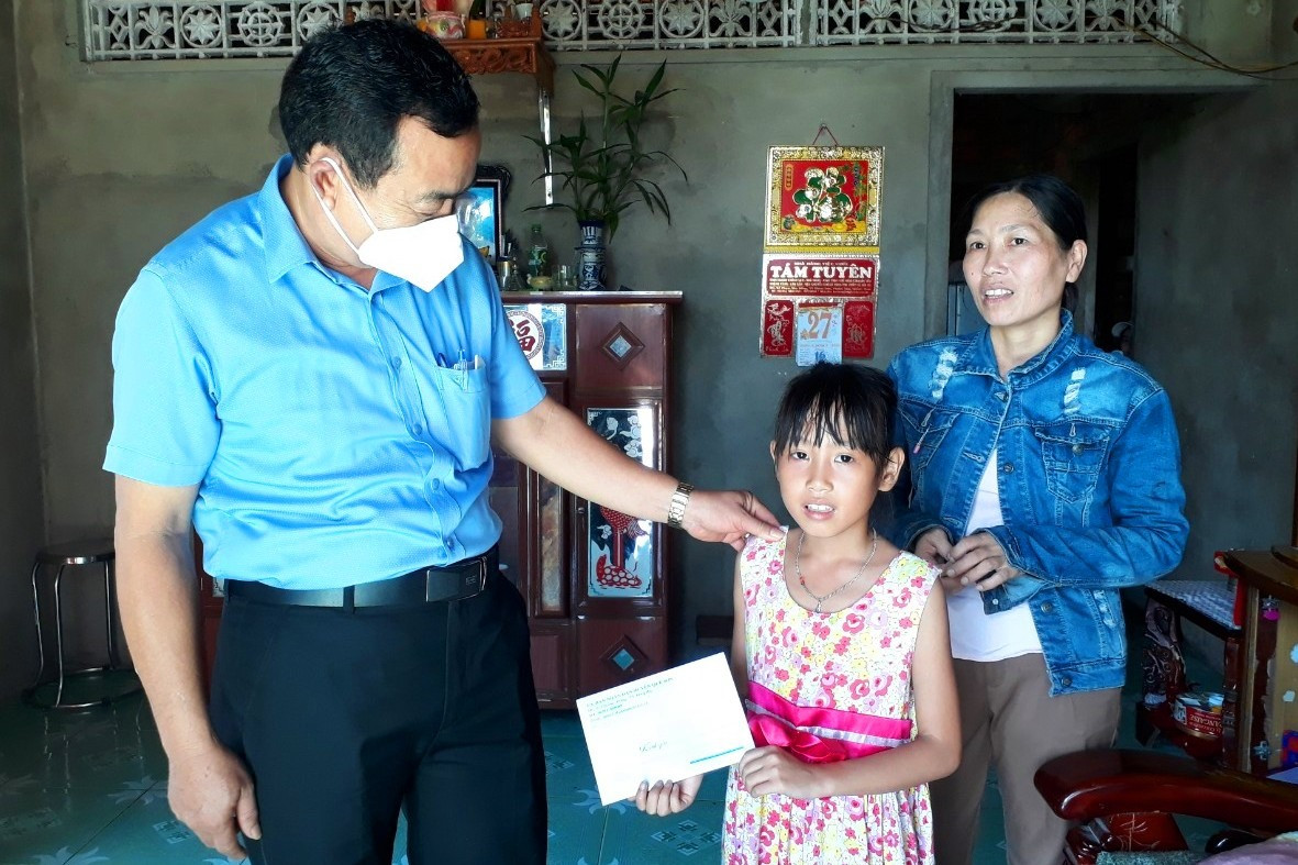 Lãnh đạo huyện Quế Sơn tặng quà cho trẻ em khó khăn tại xã Quế Minh. ảnh DT