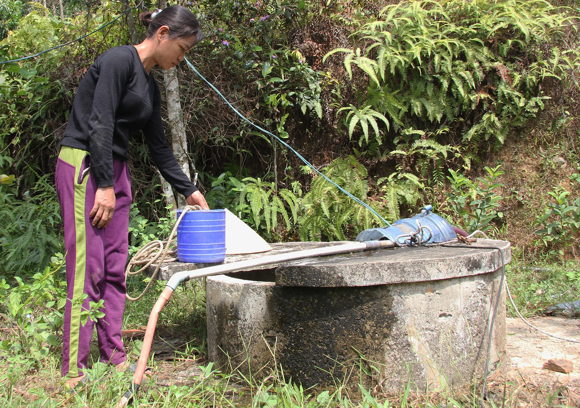 Mực nước giếng xuống thấp không thể chảy lên bồn chứa, người dân thôn Phú Trường, xã Tam Trà phải dùng gầu để múc. Ảnh: H.Q
