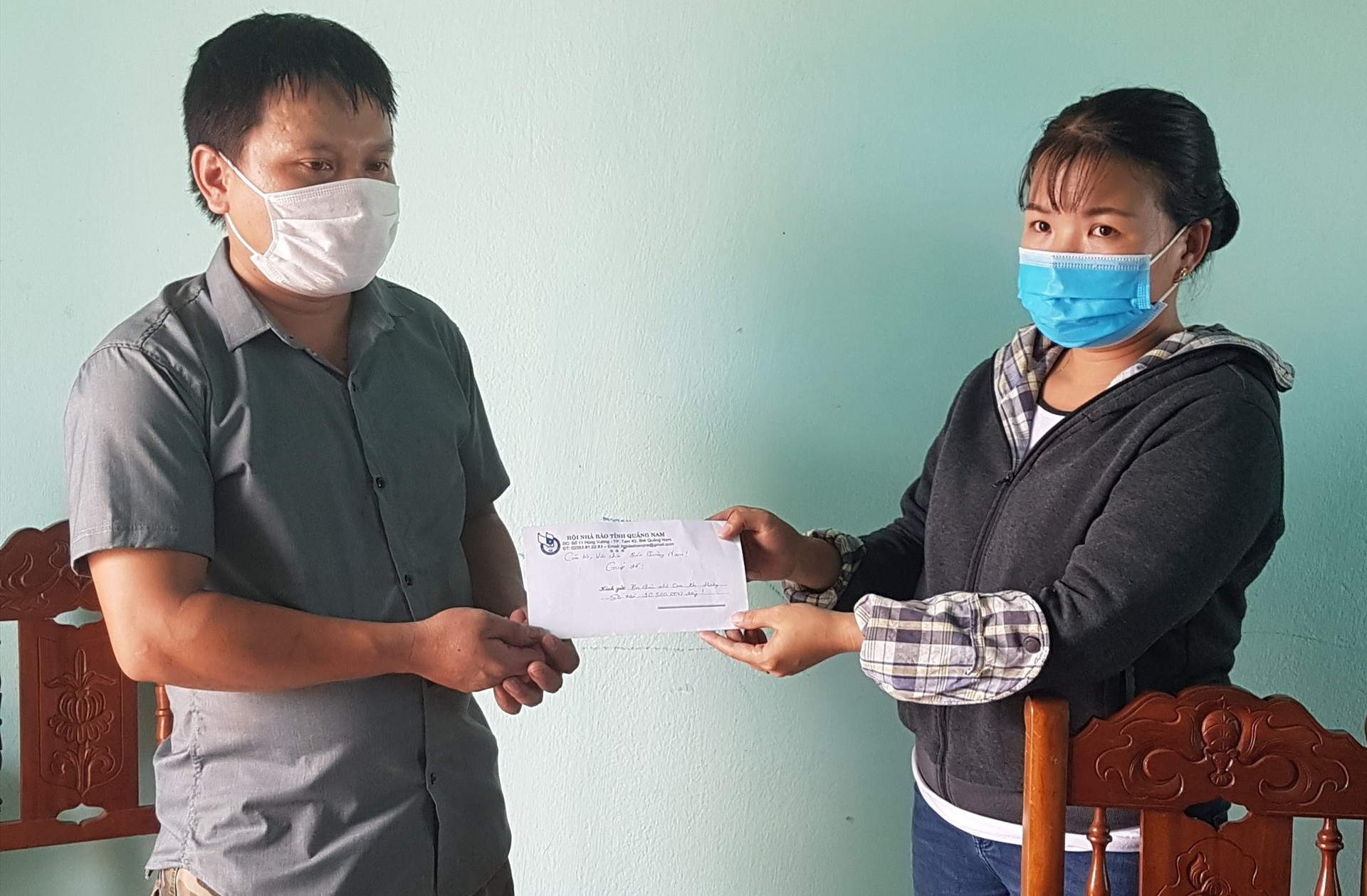 Đại diện Báo Quảng Nam trao tiền hỗ trợ ba cháu nhỏ mồ côi cho đại diện gia đình tại Tổ tiếp nhận cứu trợ xã Tiên Cảnh.