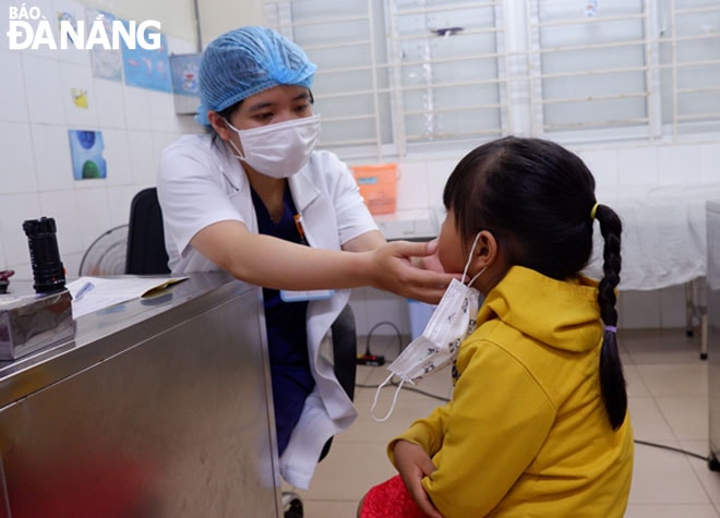 Bác sĩ đang khám cho bệnh nhi tại Bệnh viện Phụ sản-Nhi Đà Nẵng. Ảnh: PHAN CHUNG