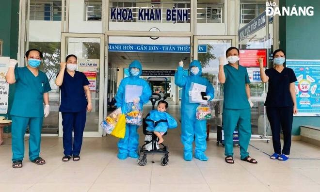3 bệnh nhân mặc đồ bảo hộ (giữa) nhận giấy xuất viện của lãnh đạo Trung tâm Y tế huyện Hòa Vang chiều 7-6. Ảnh: L.H