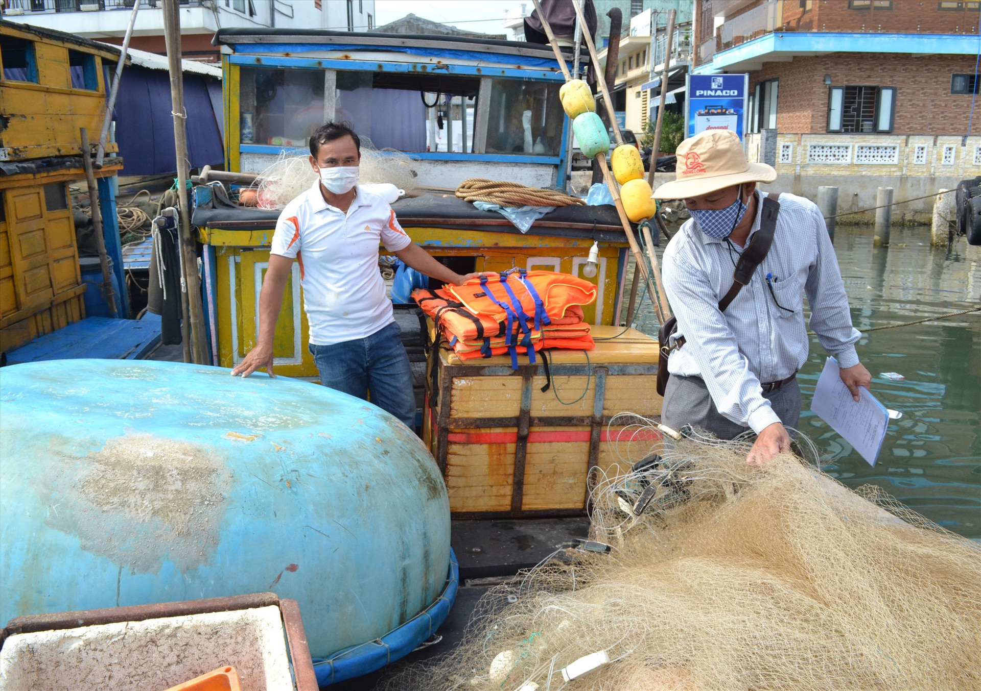 Đăng kiểm viên là cán bộ Chi cục Thủy sản Quảng Nam thực hiện đăng kiểm trên tàu cá của ngư dân huyện Núi Thành. Ảnh: VIỆT NGUYỄN