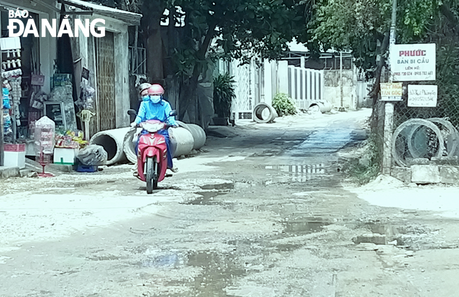Mặt đường K464 Trường Chinh, đoạn từ cống Khe Cạn vào đường Tôn Đản lồi lõm, mấp mô và có nhiều ổ gà. Ảnh: ĐẮC MẠNH