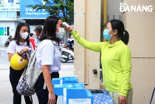 Đo thân nhiệt cho các thí sinh tham gia thi vào lớp 10 công lập, năm học 2021-2022 tại điểm thi Trường THPT Trần Phú. Ảnh: NGỌC HÀ
