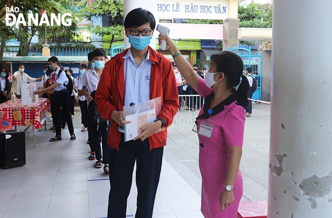 Tại các điểm thi, thí sinh được đo thân nhiệt, sát khuẩn tay bảo đảm phòng, chống Covid-19. Ảnh: NGỌC HÀ