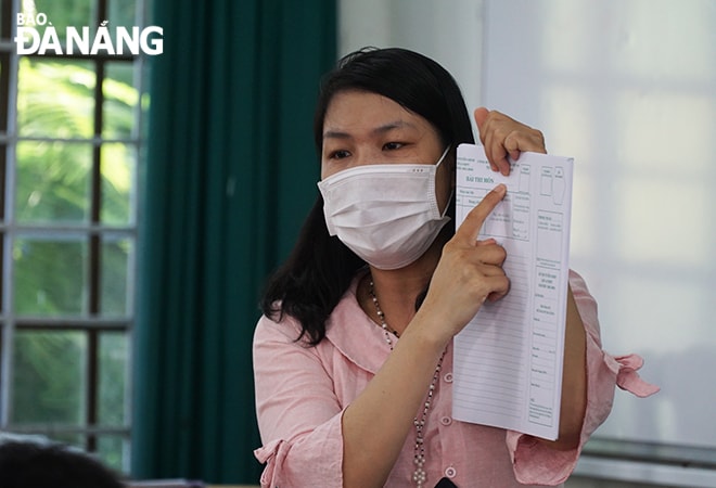 Cán bộ điểm thi hướng dẫn thí sinh điền thông tin trước khi làm bài. Ảnh: XUÂN DŨNG