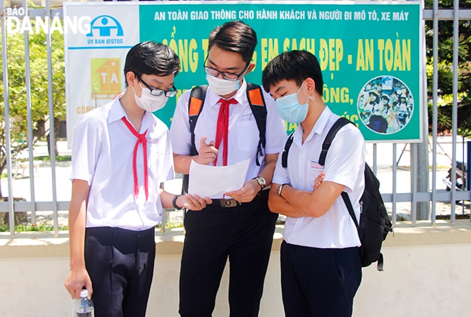 Các thí sinh trao đổi bài làm sau khi buổi thi môn Ngữ văn kết thúc. Ảnh: XUÂN DŨNG