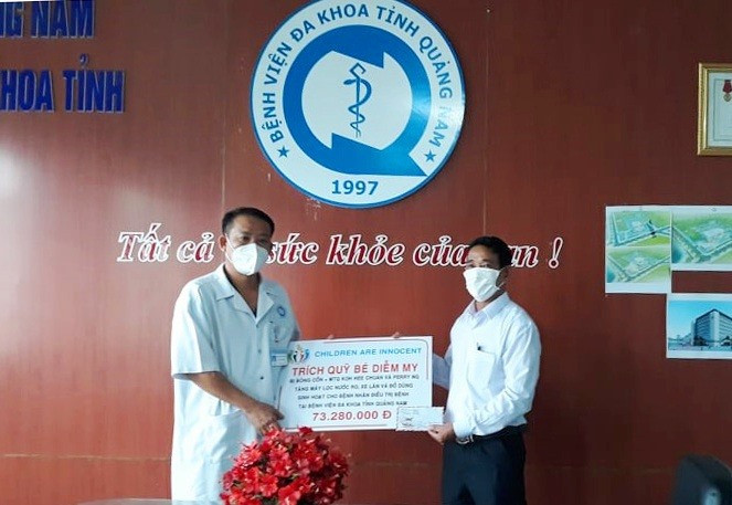 Chủ tịch Hội Từ thiện Quảng Nam (phải) trao biển hỗ trợ tượng trưng cho Bệnh viện Đa khoa Quảng Nam. Ảnh: C.N