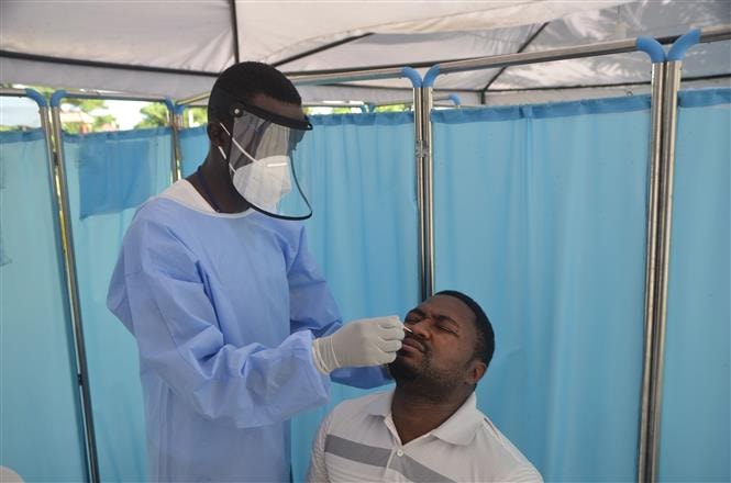 Nhân viên y tế lấy mẫu xét nghiệm cho hành khách tại sân bay quốc tế Entebbe, Uganda, ngày 9/6/2021. Ảnh: THX/ TTXVN