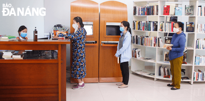 Hiện nay, người đến mượn sách tại Thư viện Khoa học Tổng hợp Đà Nẵng đứng giãn cách, bảo đảm phòng, chống dịch. Ảnh: XUÂN DŨNG