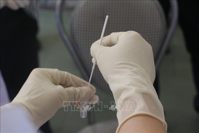 Lấy mẫu xét nghiệm Covid-19. Ảnh: Bích Huệ/TTXVN