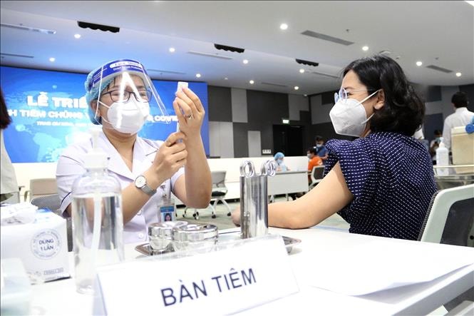 Các y, bác sỹ chuẩn bị thuốc tiêm chủng vaccine phòng Covid-19 cho người lao động. Ảnh: Thanh Vũ/TTXVN