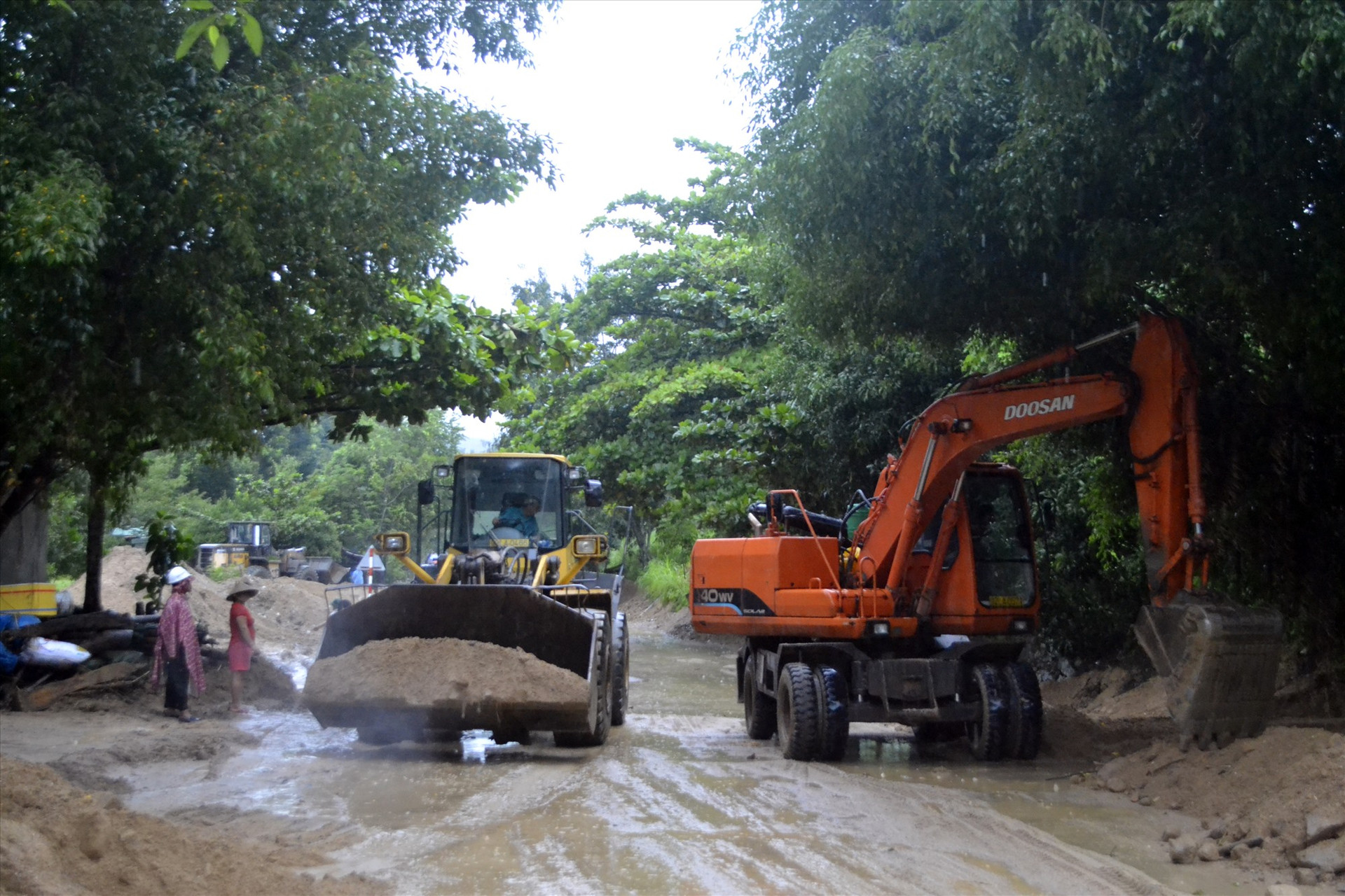 Khẩn trương xúc dọn đất, đá, cây cối sạt lở trên quốc lộ 14B, đoạn qua huyện Nam Giang. Ảnh: TCT