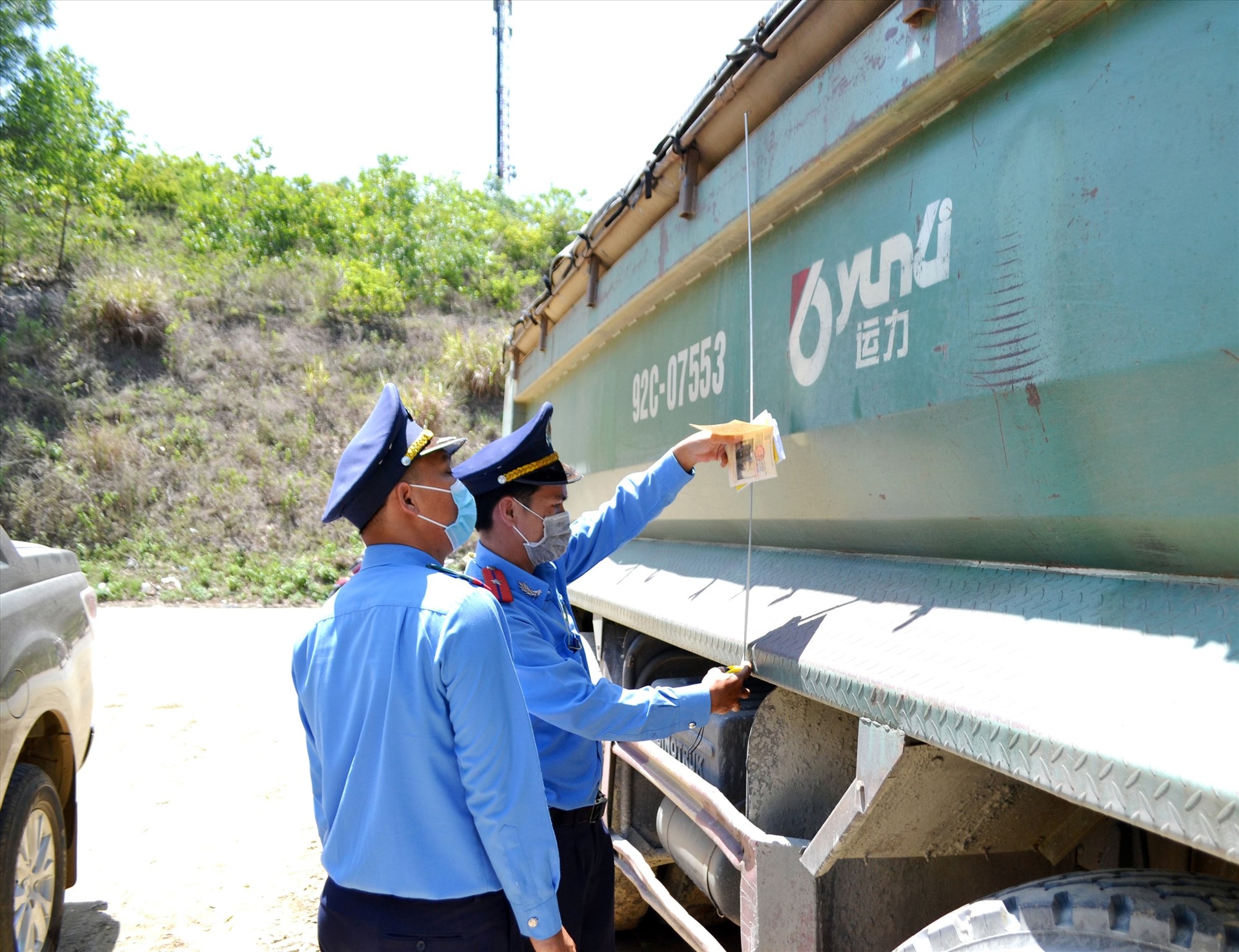 Thành viên Tổ kiểm tra liên ngành cấp tỉnh đo kích thước thùng xe tải chở hàng trên tuyến ĐT609 qua địa phận Đại Lộc. Ảnh: N.B