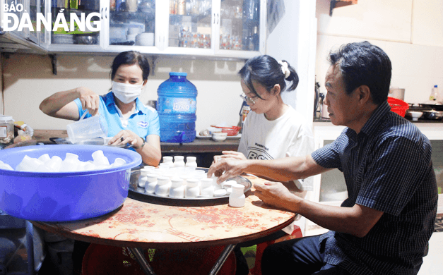 Gia đình anh Nguyễn Sơn Triều và chị Trương Thị Trinh cùng nhau làm sữa chua để tăng thêm thu nhập. Ảnh: XUÂN DŨNG
