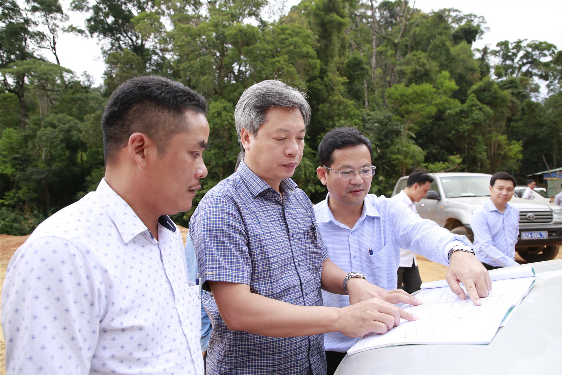 Phó Chủ tịch UBND tỉnh Hồ Quang Bửu trao đổi với lãnh đạo huyện Phước Sơn về tiến độ thực hiện mặt bằng khu tái định cư thôn 3 (thôn 6 cũ) của xã Phước Lộc.