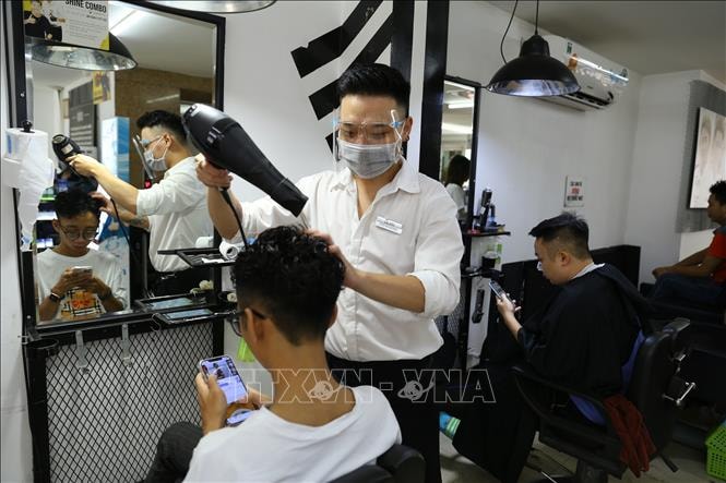 Một cửa hàng cắt tóc, gội đầu trên phố Lạc Trung đông khách trong ngày mở cửa trở lại. Ảnh: Hoàng Hiếu/TTXVN