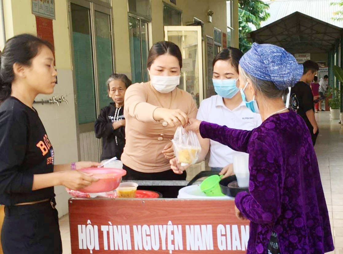 Thành viên Hội Thiện nguyện Nam Giang phát cháo miễn phí cho bệnh nhân và người nhà tại Trung tâm Y tế huyện. Ảnh: T.T