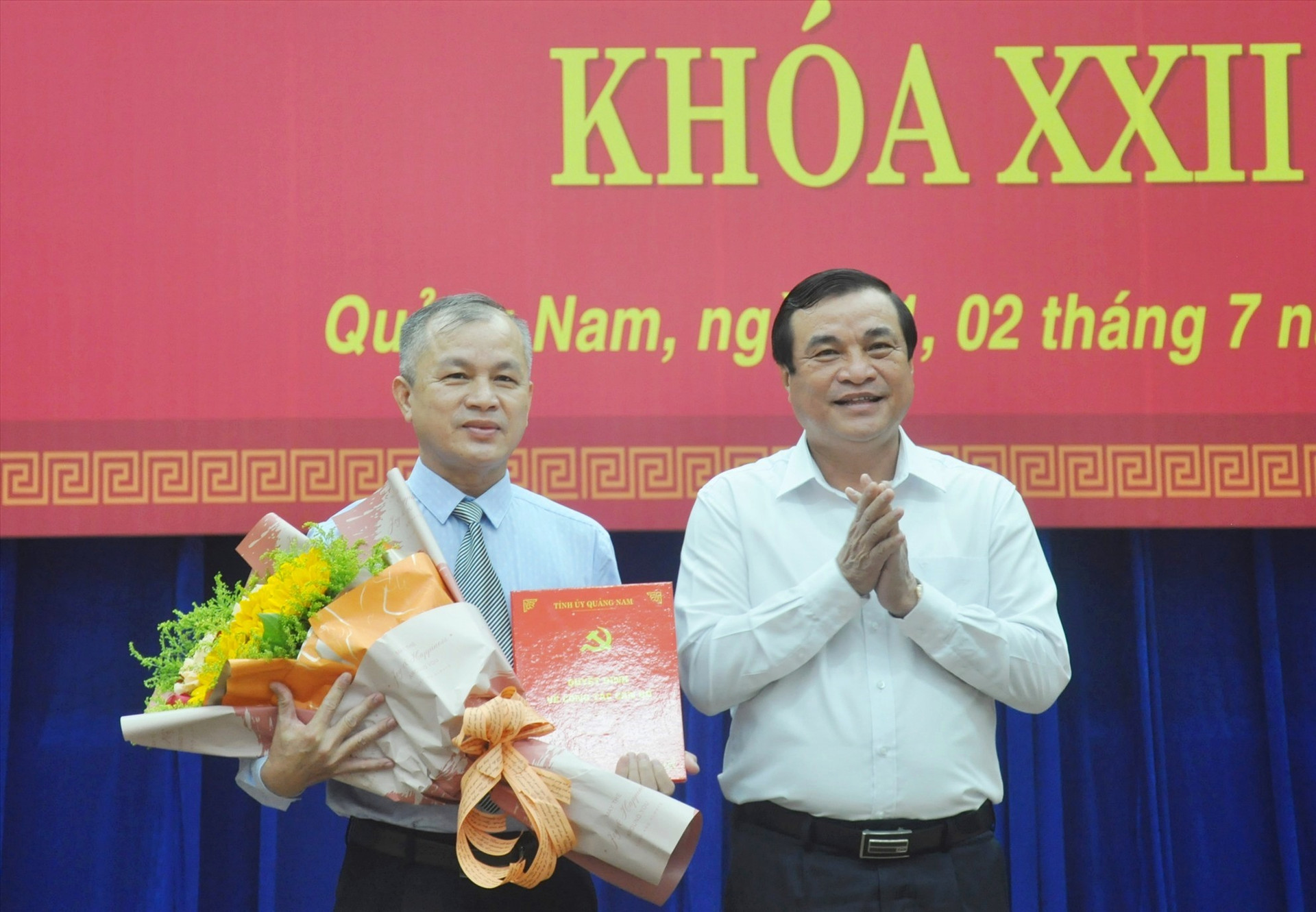 Bí thư Tỉnh ủy Phan Việt Cường trao quyết định chuẩn y và tặng hoa chúc mừng đồng chí Nguyễn Đức Tiến. Ảnh: N.Đ