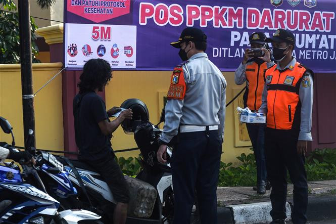 Nhân viên Bộ giao thông phát khẩu trang cho người dân để phòng tránh lây nhiễm COVID-19 tại Jakarta, Indonesia, ngày 3/7/2021. Ảnh: THX/TTXVN