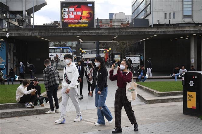 Người dân đeo khẩu trang phòng dịch Covid-19 tại Manchester, Anh ngày 25-3-2020. Ảnh: AFP/TTXVN