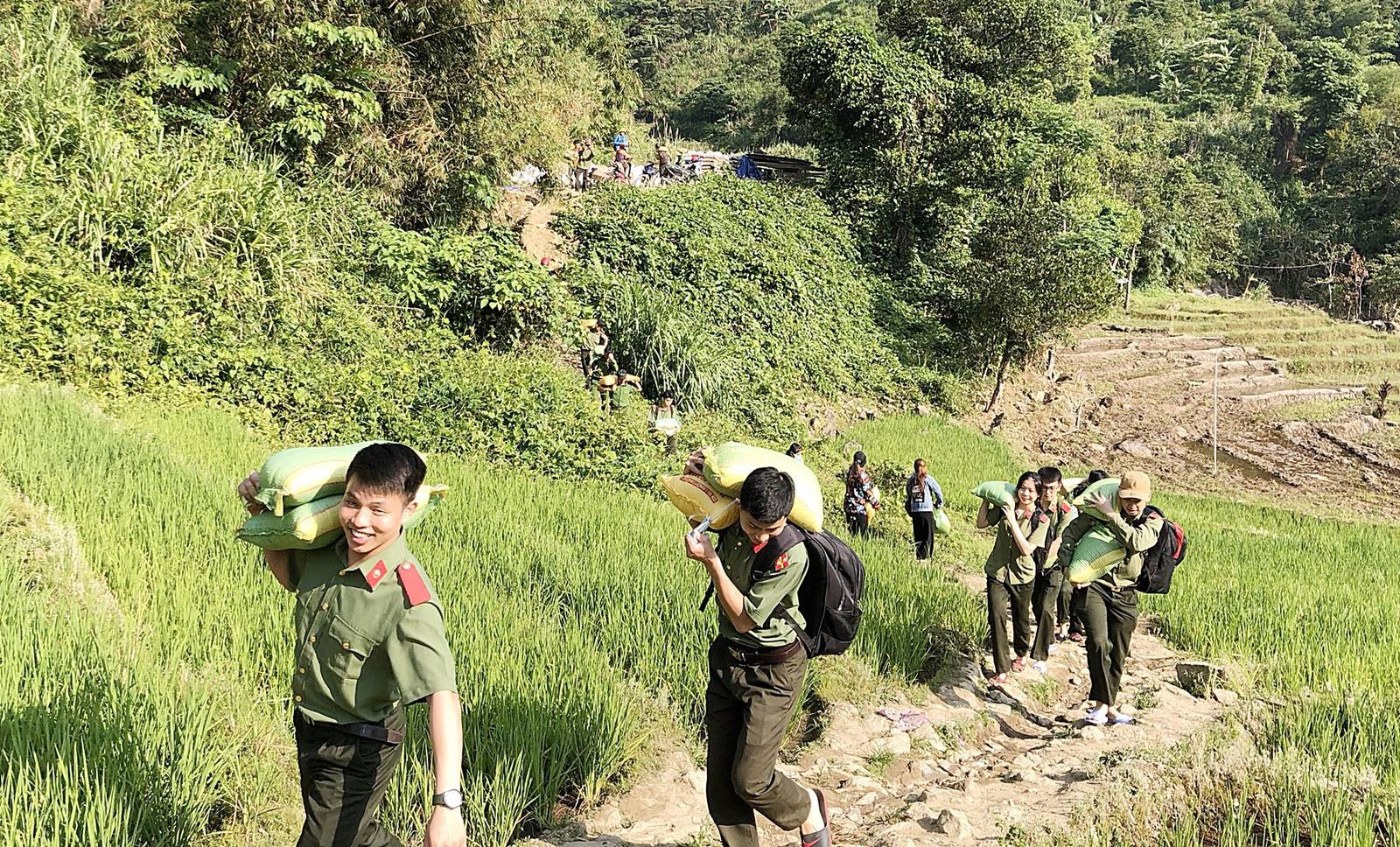 Tuổi trẻ lực lượng An ninh cõng gạo hỗ trợ đồng bào xã Trà Nam, huyện Nam Trà My. Ảnh: Công an Nam Trà My.