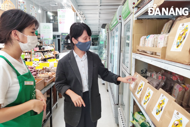 Chị Xuân Ly (phải) đang kiểm tra gạo tươi xay xát tại chỗ tại cửa hàng Vita Market trên đường Hoàng Văn Thụ (quận Hải Châu). Ảnh: THU HÀ