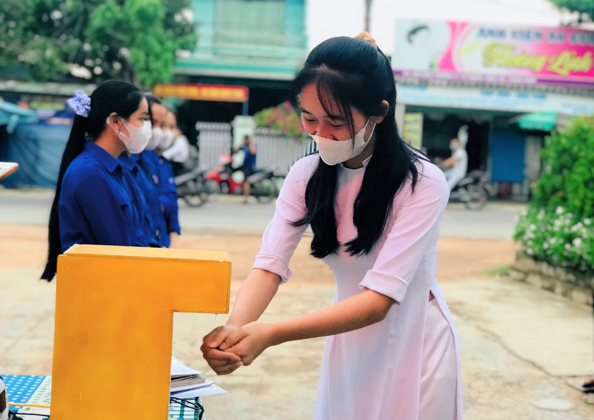 Thí sinh rửa tay sát khuẩn bằng máy sát khuẩn tự động tại điểm thi Trường THPT Lý Tự Trọng (xã Bình Trị, huyện Thăng Bình). Ảnh: VĂN ĐỨC