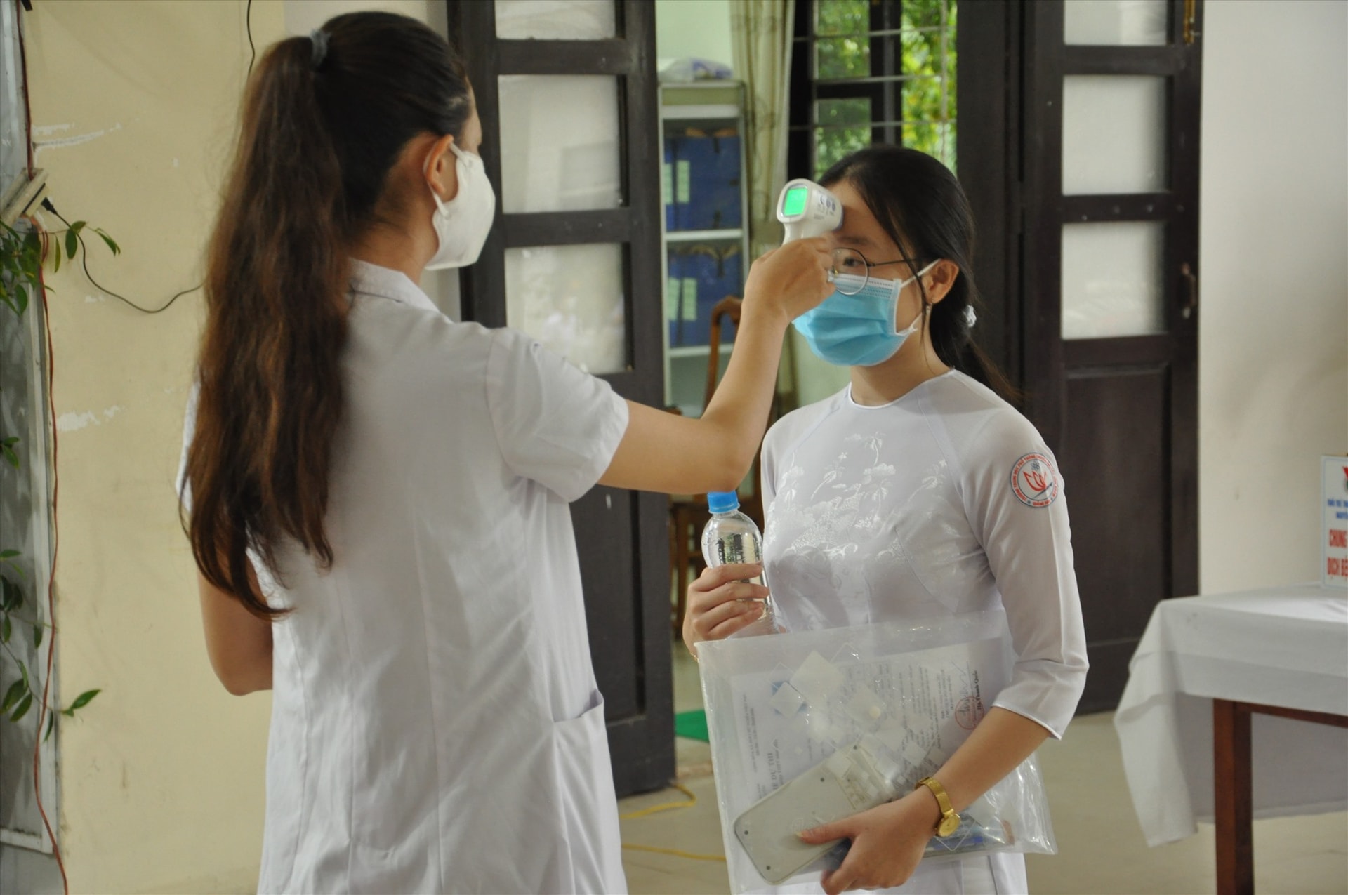 Đo thân nhiệt cho thí sinh trước khi vào khu vực thi. Ảnh: X.P