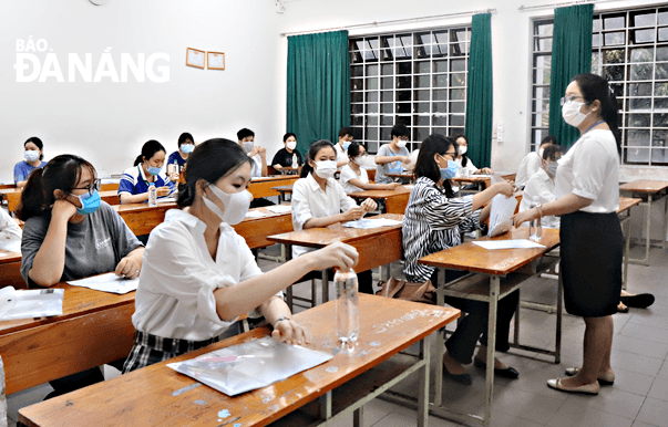 Cán bộ coi thi dặn dò thí sinh trước khi thi tại điểm thi Trường THPT Phan Châu Trinh. Ảnh: NGỌC HÀ
