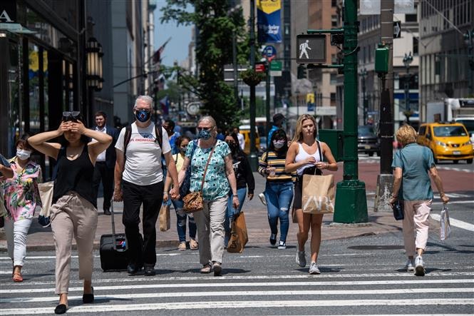 Người dân di chuyển trên một tuyến phố ở New York, Mỹ. Ảnh: AFP/TTXVN