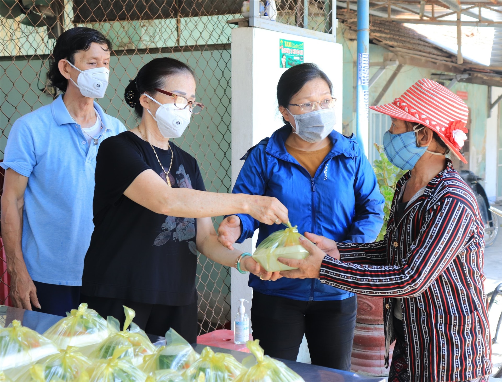 Vợ chồng cô Sen phát cơm chia sẻ khó khăn mà dịch cùng bà con.