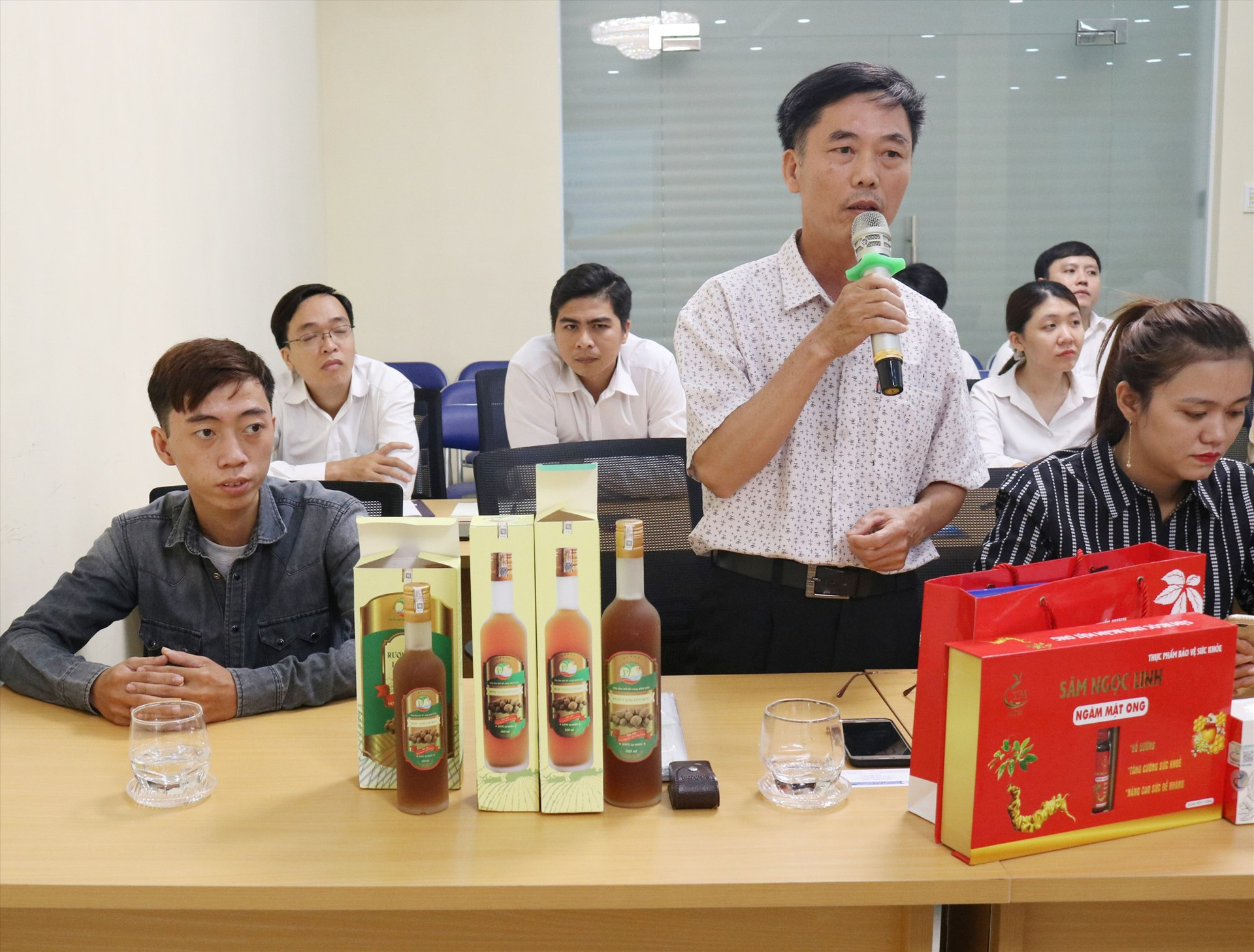 Đại diện HTX Phước Tuyên (Tiên Phước) giới thiệu sản phẩm rượu vang lòn bon tại diễn đàn xúc tiến thương mại do Sở Công Thương tổ chức. Ảnh: P.H