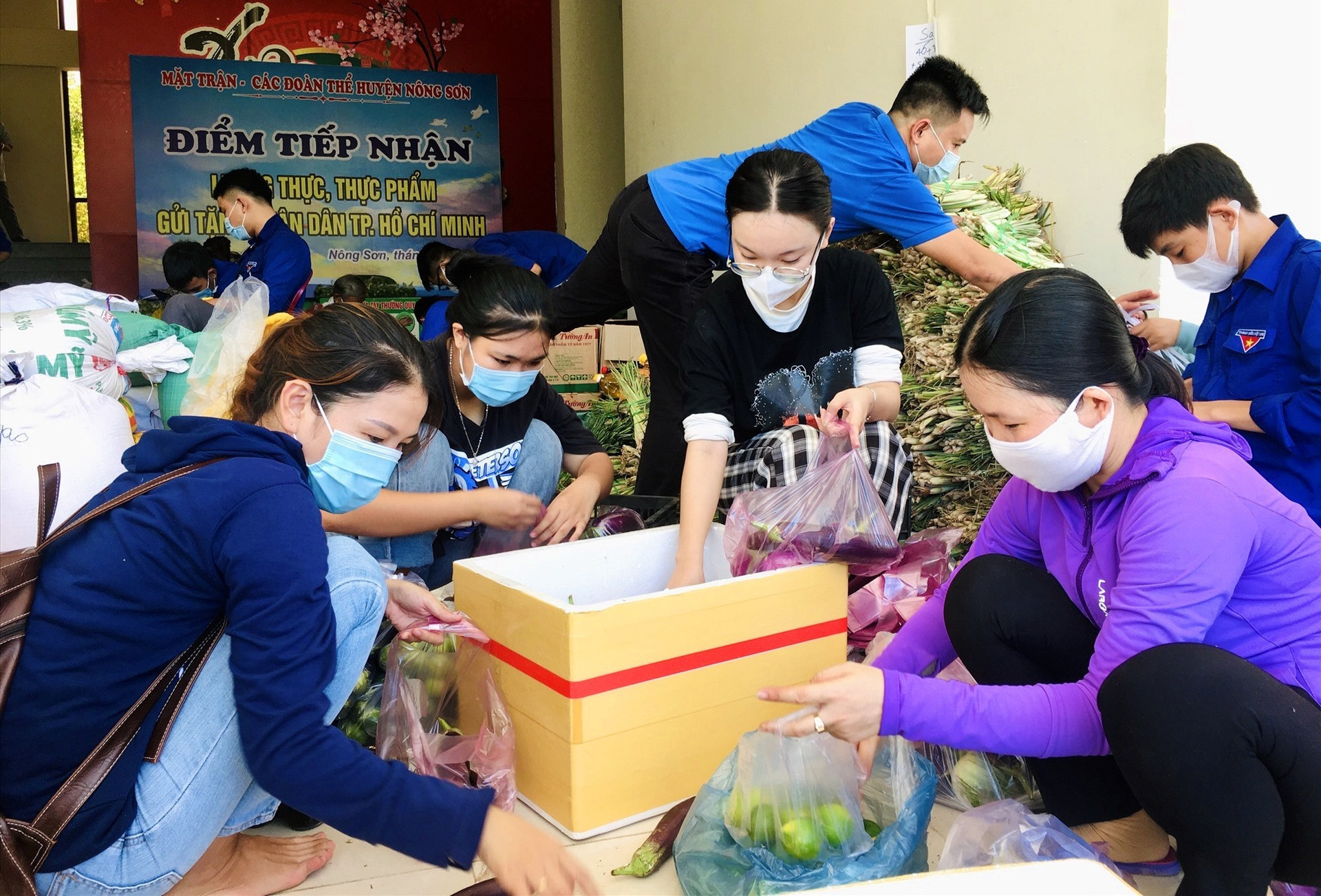 Các tình nguyện viên khẩn trương phân loại, đóng gói thực phẩm để gởi vào TP. Hồ Chí Minh sớm nhất. Ảnh: LÊ THÔNG