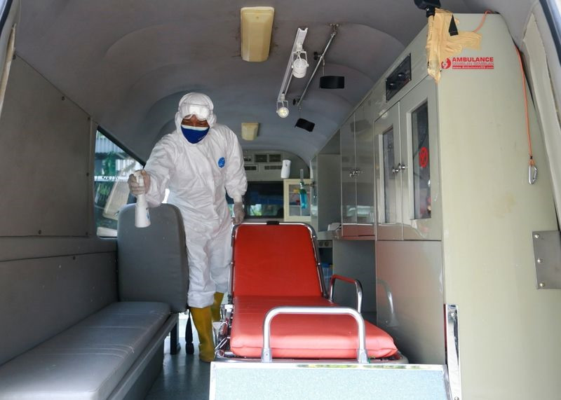 Một tình nguyện viên phun thuốc sát khuẩn trước và sau khi vận chuyển bệnh nhân Covid-19 ở Jakarta. Ảnh: Reuters
