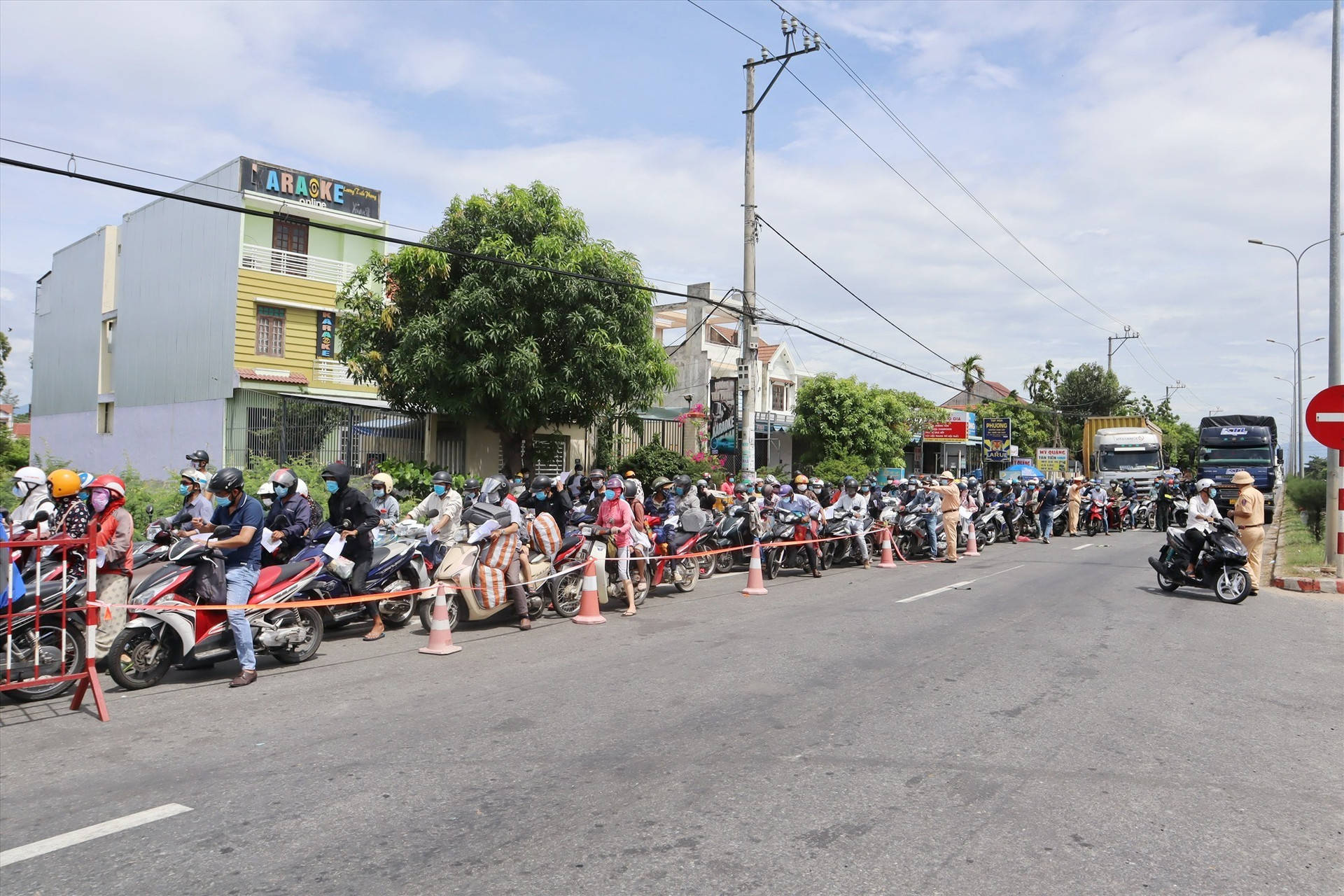Đến 11 giờ trưa nay, vẫn còn hàng trăm người dân nối đuôi nhau chờ qua chốt để về Quảng Nam. Ảnh: Q.T