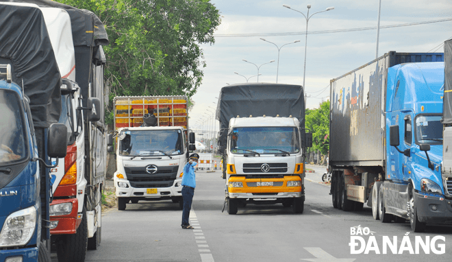 Lực lượng chức năng hướng dẫn xe vào chốt kiểm soát phòng, chống dịch trên quốc lộ 1A, gần Trạm Cảnh sát giao thông cửa ô Hòa Phước, huyện Hòa Vang. (Ảnh chụp ngày 21-7)Ảnh: THÀNH LÂN