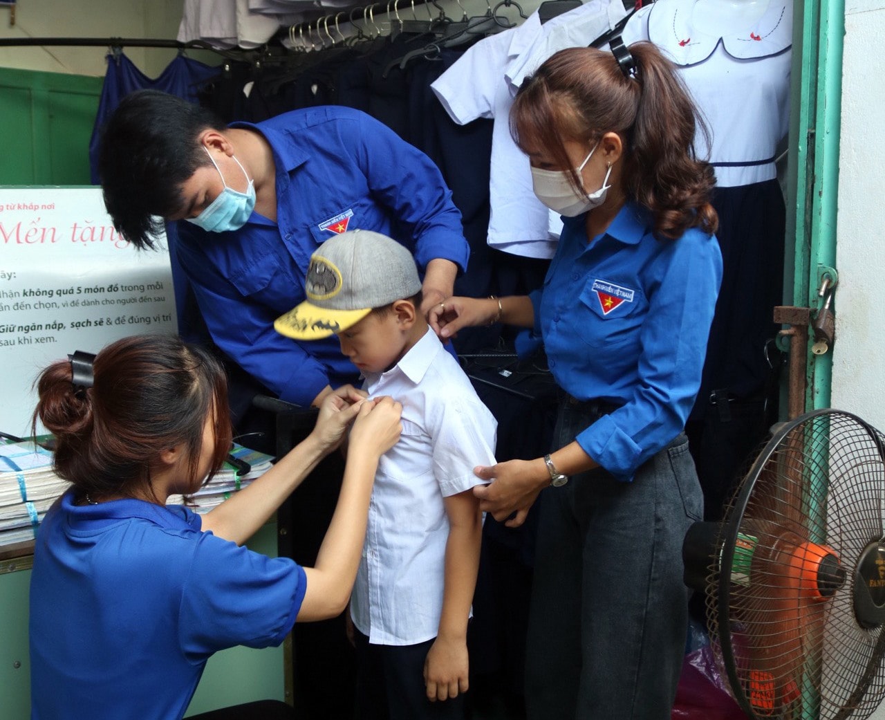 Thanh niên tình nguyện của chi đoàn thôn Hội Sơn giúp các em học sinh nghèo thử đồ và chọn lựa những bộ đồng phục học sinh phù hợp.