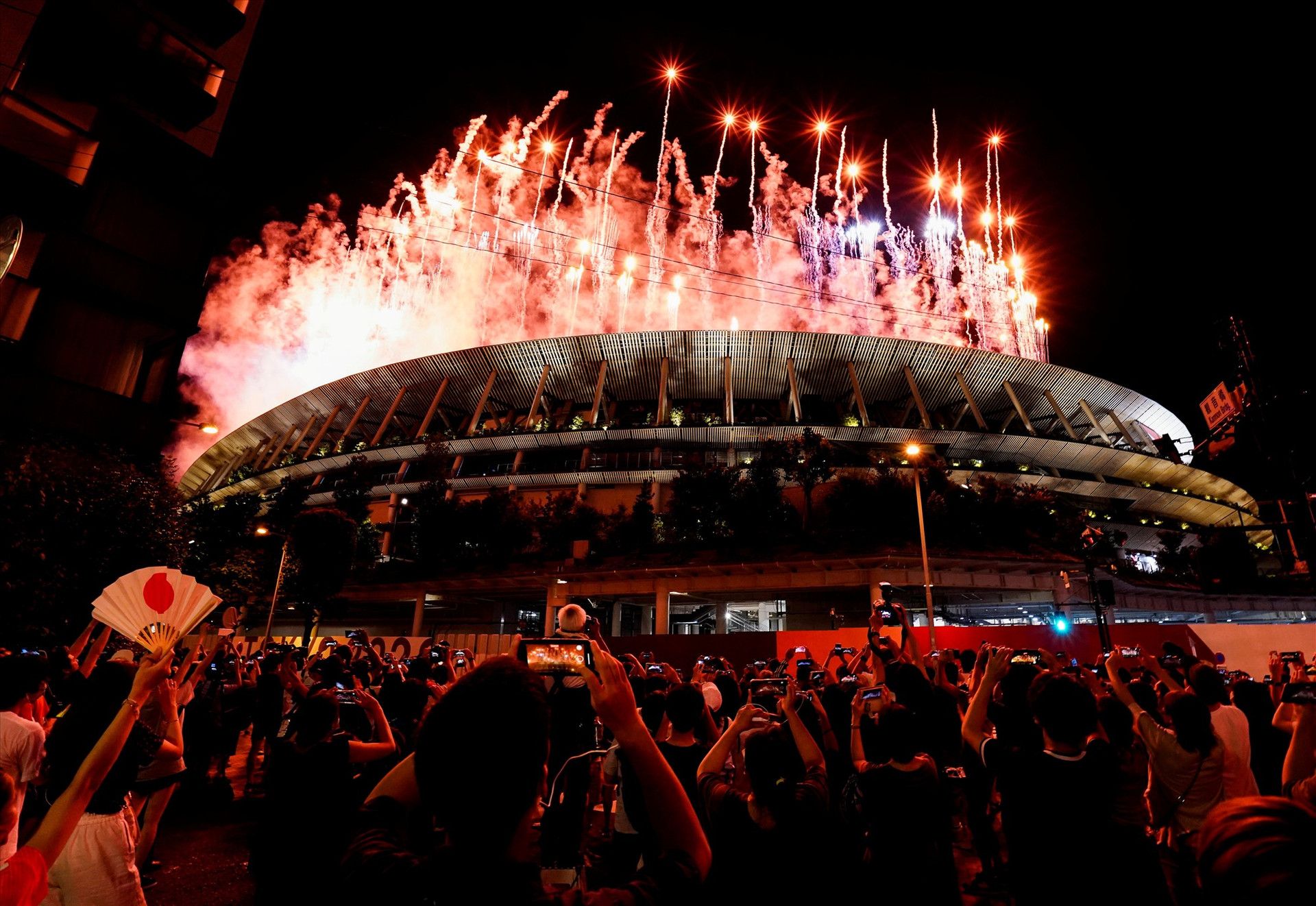 Không được vào sân để trực tiếp theo dõi buổi lễ khai mạc, nhiều người vẫn háo hức ghi lại những hình ảnh ngoạn mục ngay từ bên ngoài sân vận động Olympic. Ảnh: Reuters