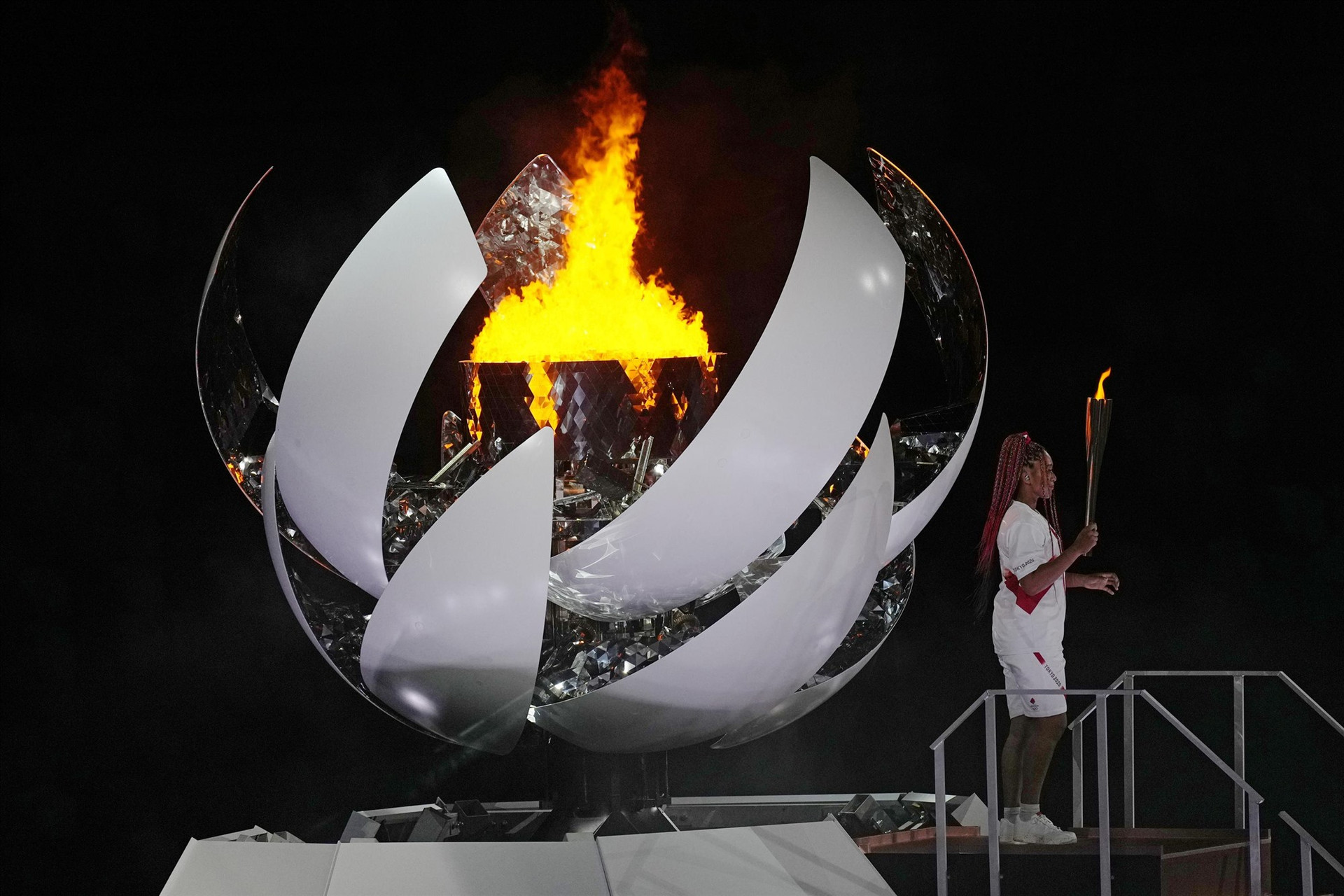 Vận động viên quần vợt Naomi Osaka thắp sáng ngọn lửa Olympic trong lễ khai mạc ngày 23.7. Ảnh: AP